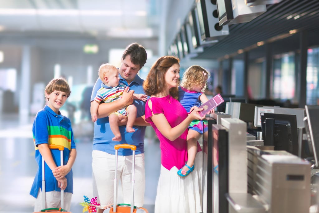 Jak zaprowadzić ład w domowych finansach po wakacyjnych wyjazdach? - rodzina z dziećmi na lotnisku przy odprawie. 