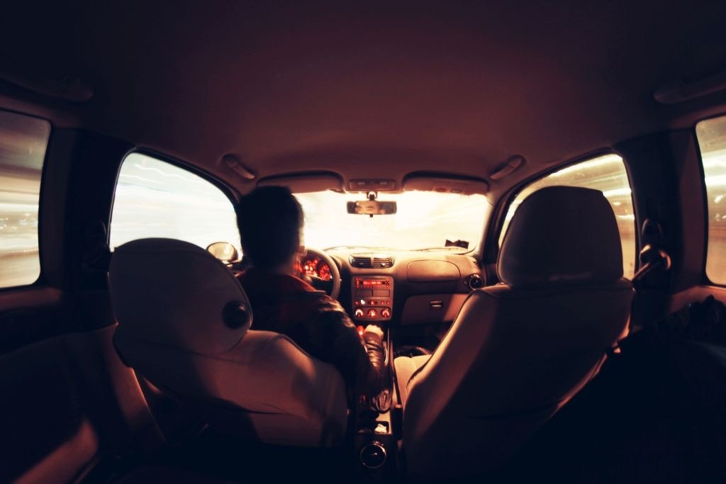 5 sposobów na tanią jazdę samochodem - wnętrze auta i mężczyzna siedzący za kierownicą.
