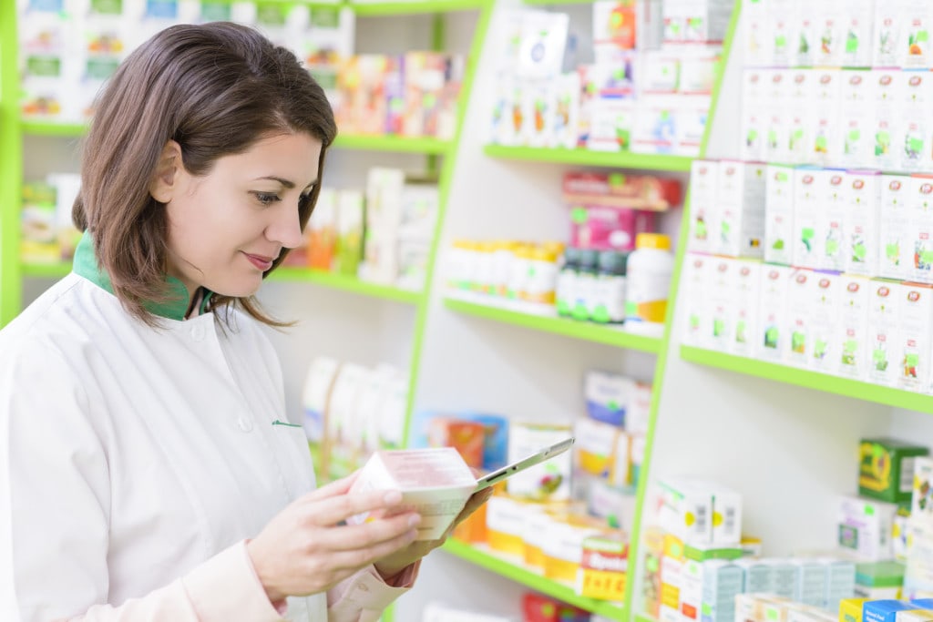 Nastroje konsumentów - czy nadchodzi odwilż w turystyce? - kobieta w aptece czyta skład leku na opakowaniu.