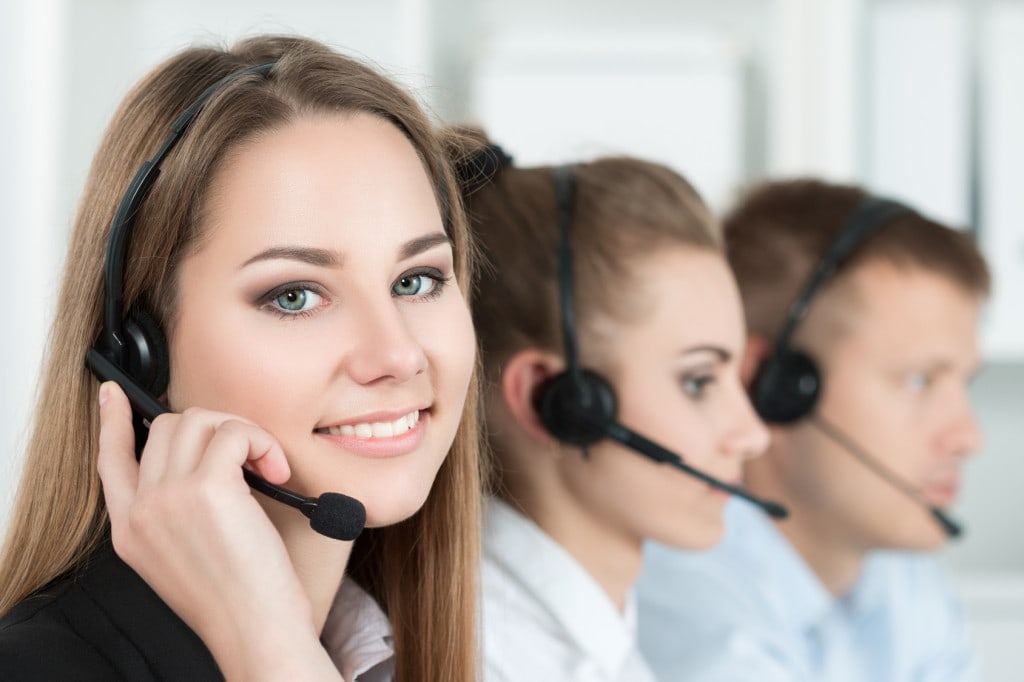 Infolinia dla przedsiębiorców 24h - wsparcie PAIH- kobiety i mężczyzna ze słuchawkami na głowie rozmawiają przez telefon.