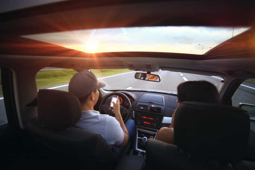 Carpooling, czyli sąsiedzkie lub koleżeńskie podwózki coraz popularniejsze - kobieta i mężczyzna podróżują autem.