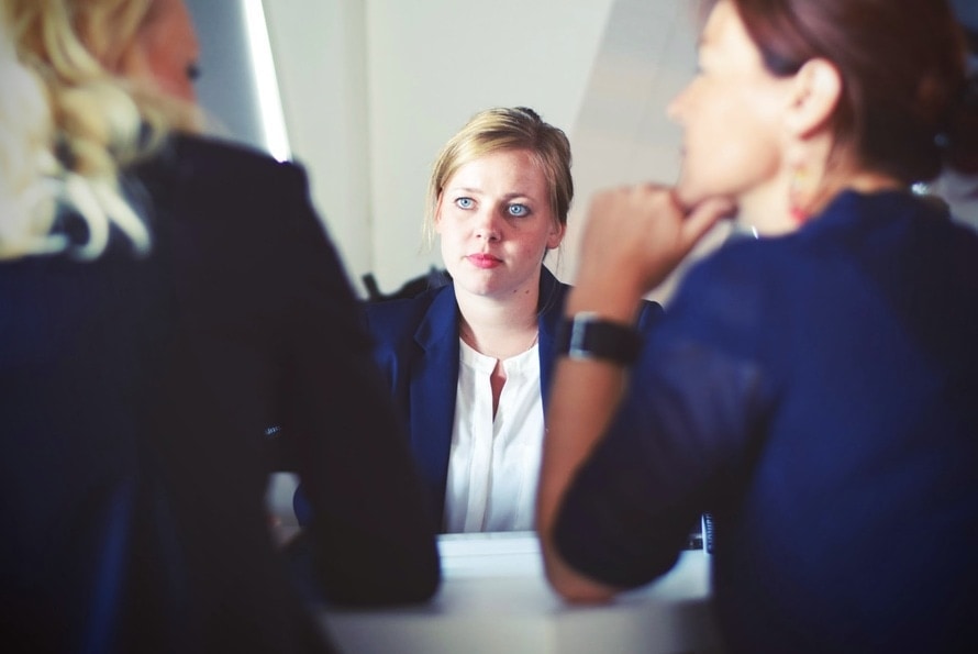 Rozmowa rekrutacyjna-czego nie robić na spotkaniu o prace?- trzy kobiety siedzą przy stole i rozmawiają