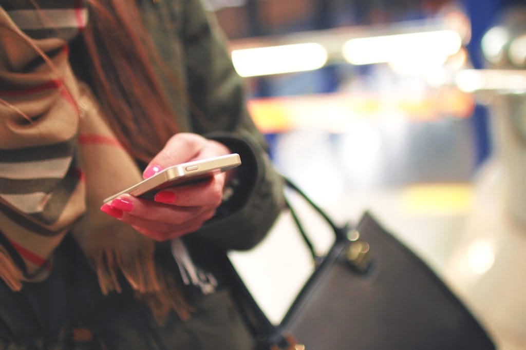 Customer Experience – jeden z najważniejszych trendów w branży retail w 2022 r. - kobieta trzyma w rekach telefon. 