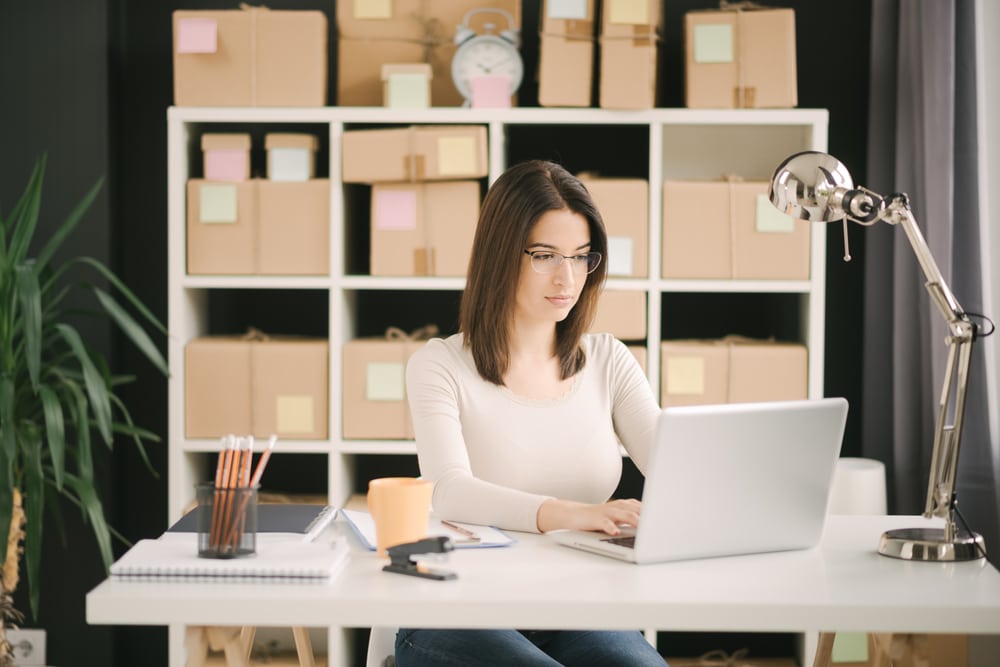 Kobiety zarabiają mniej, rzadziej zajmują wyższe stanowiska - jak to zmienić?- kobieta siedzi przy biurku i pisze na klawiaturze laptopa.