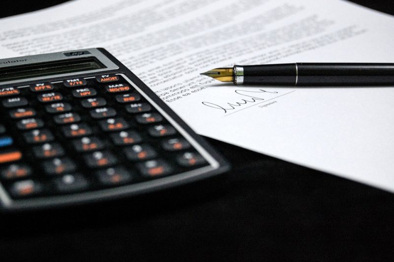 Zwolnienie z opłacania składek w przypadku nadpłaty - kalkulator i dokumenty leża na stole.