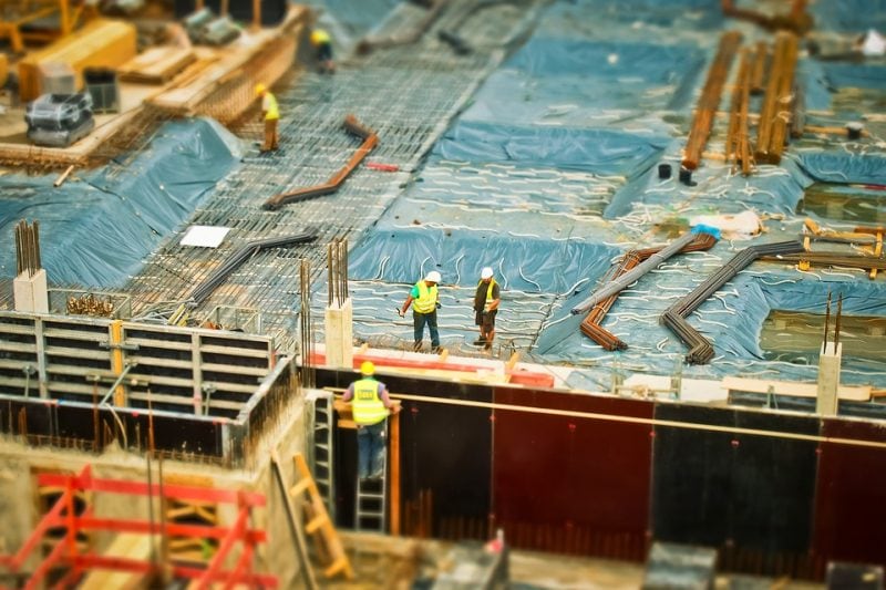 Wizja sądu mobilizuje dłużników z branży budowlanej do spłaty - pracownicy na budowie budynku. 