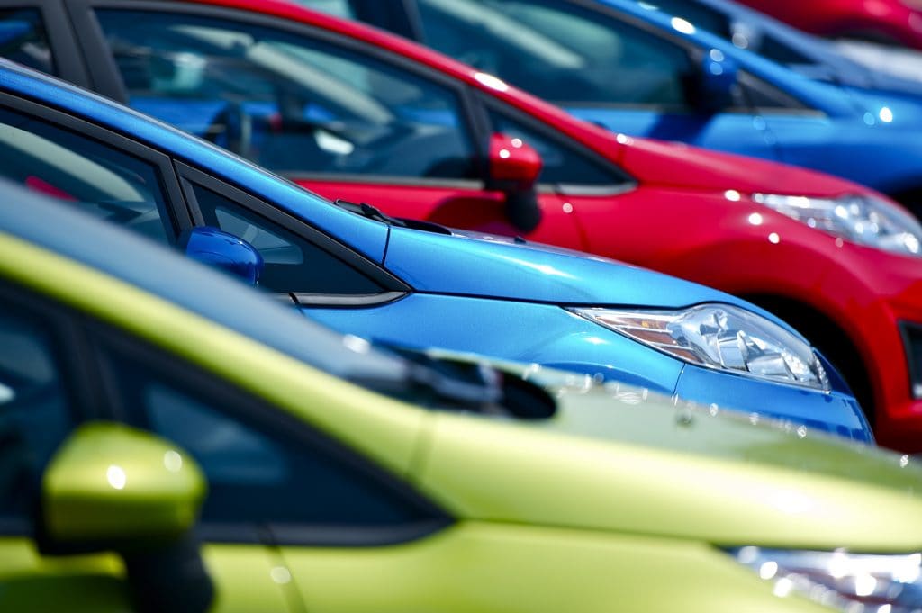 Jak drożejące auta wpływają na decyzje zakupowe Polaków - kolorowe auta stoją w szeregu. 