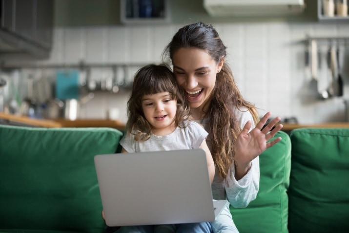 Kolejki przed sklepami - pomoże sztuczna inteligencja - Matka z córką przed laptopem na zielonej kanapie