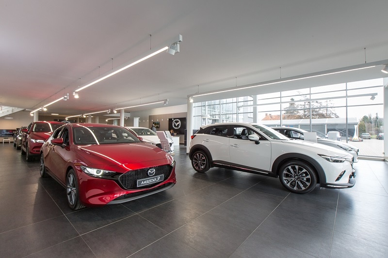 Mazda prognozuje dalsze ożywienie sprzedaży na świecie - auta marki Mazda w salonie samochodowym.