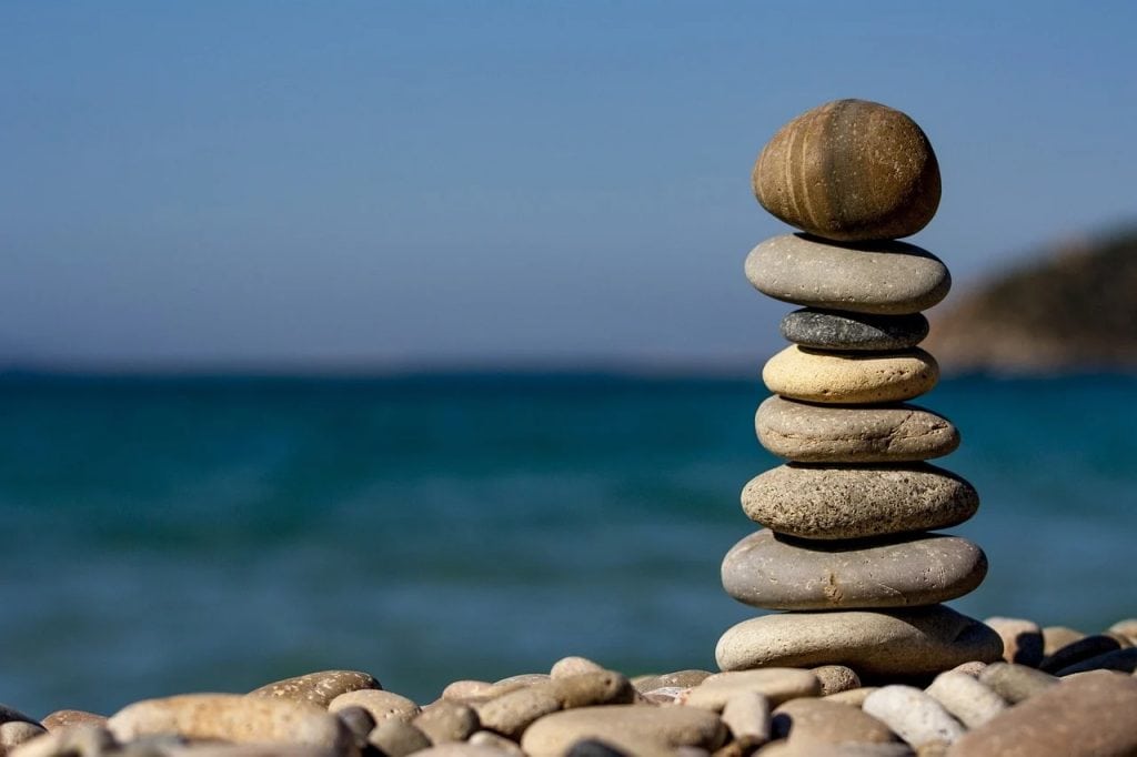 Odwaga i równowaga, czyli work-life balance po polsku-kamienie położone jeden na drugim, w oddali morze i plaża