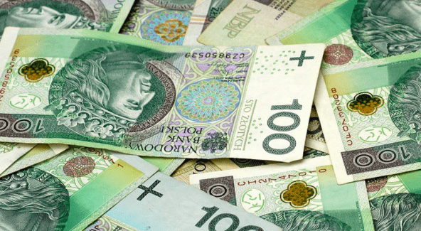 CIT Estoński vs CIT klasyczny - które rozwiązanie jest dla kogo? - banknoty 100 złotowe leżą rozsypane na stole. 