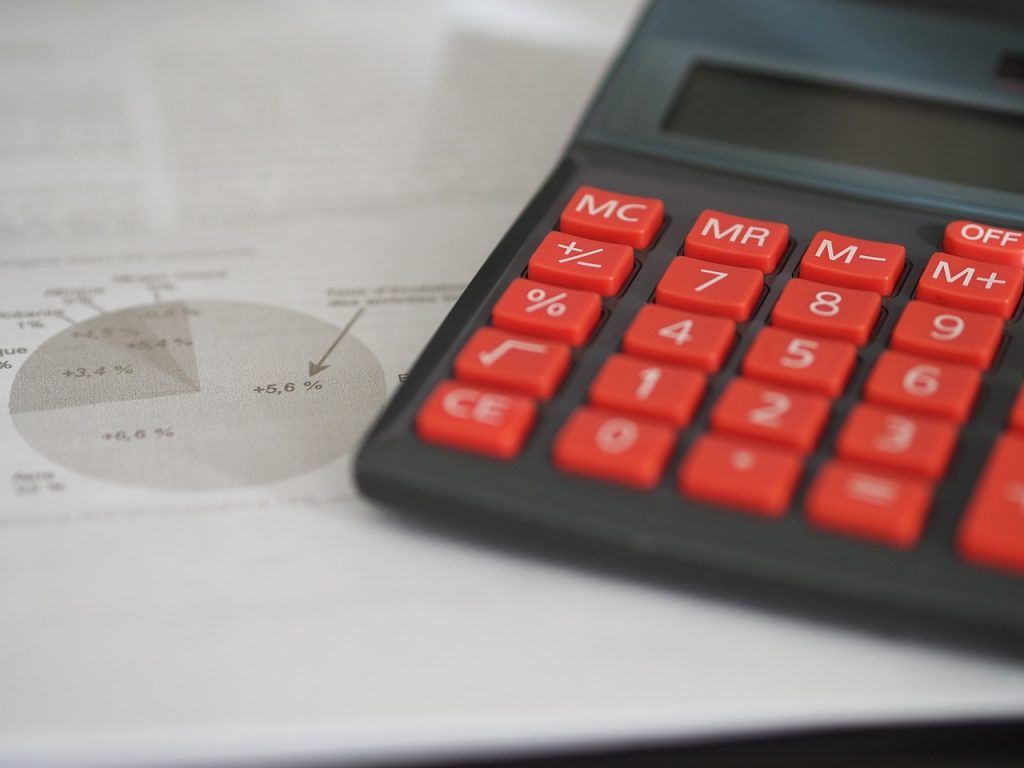 Upadłość firm. Bankruci zalegają ponad 50 milionów zł - na biurku leżą kalkulator i dokumenty.