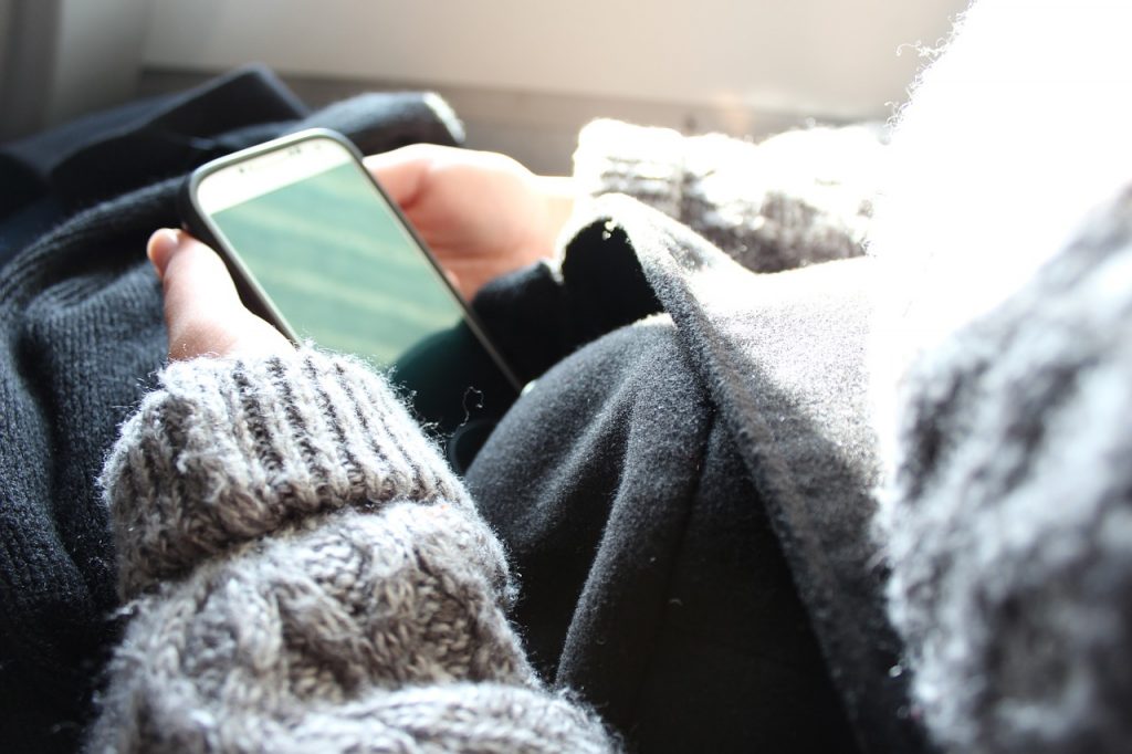 Wsparcie dla osób w depresji od banku BNP Paribas -kobieta siedzi i trzyma telefon w ręku. 