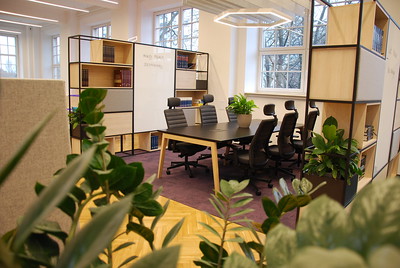 SGH z nowoczesną przestrzenią do coworkingu- duże biurko z krzesłami na sali. 