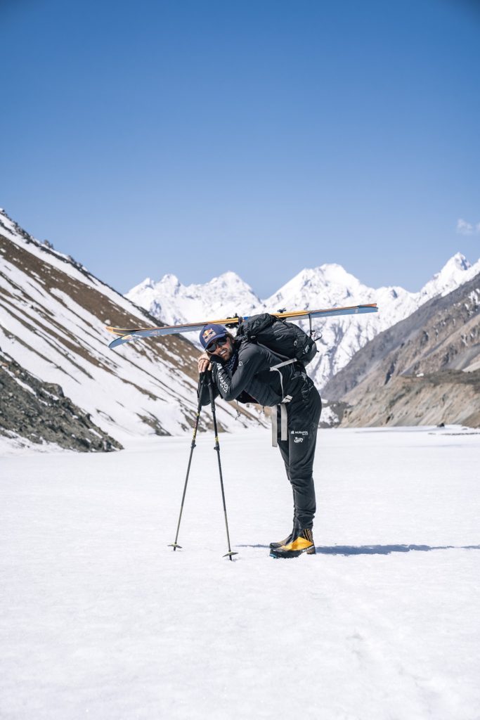 Andrzej Bargiel - nieustraszony skialpinista. Wywiad z mistrzem - mężczyzna stoi w górach na śniegu i opiera się o kijki do nart