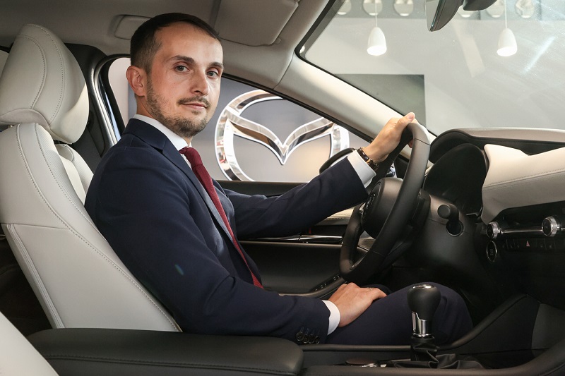 Jakub Jaczewski nowym szefem ds. Sprzedaży Flotowej i Samochodów Używanych Mazda Motor Poland - mężczyzna siedzi w aucie.
