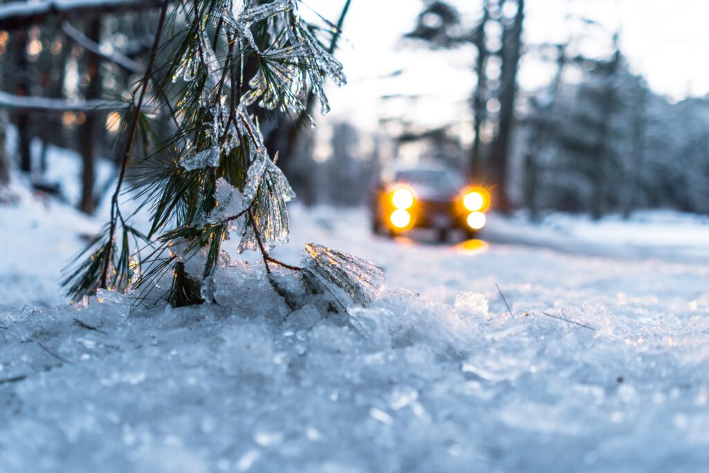 5 wskazówek jak przygotować samochód do zimowych podróży - auto jedzie po zaśnieżonej ulicy. 