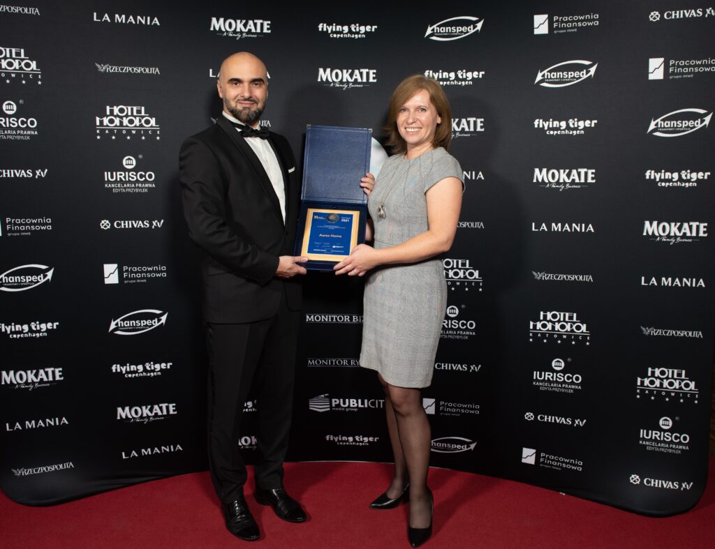 Aurec Home z prestiżową nagrodą Symbol 2021 - kobieta i mężczyzna trzymają w rękach nagrodę. 