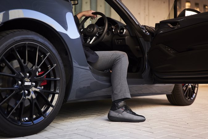 Mazda stworzyła buty do jazdy samochodem - noga mężczyzny wystająca z auta. 