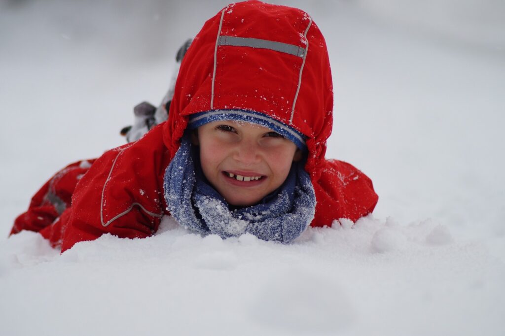 Dłuższa ważność Bonu turystycznego - dziecko lezy w śniegu. 