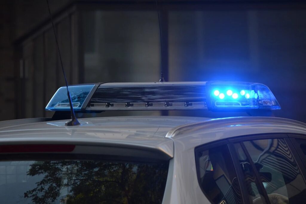 Pijany kierowca straci auto? - policyjne auto ze świecącymi na niebiesko kogutami. 