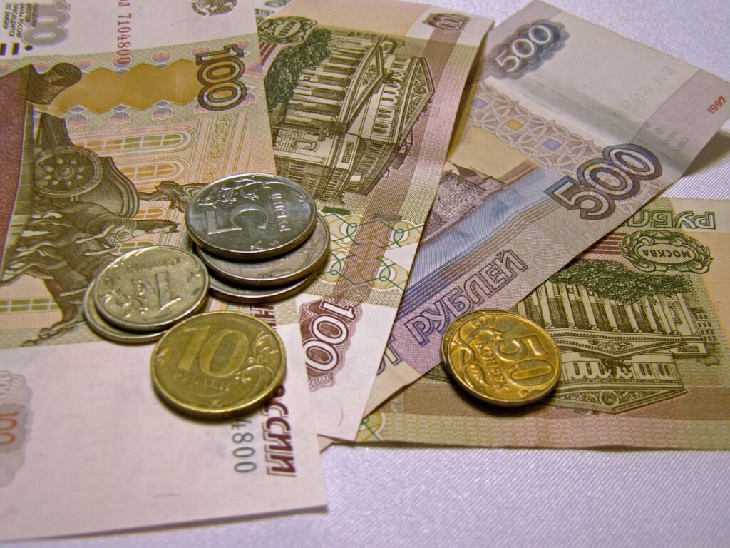 Rosyjski przemysł w recesji. Sankcje pogłębią kryzys - banknoty i monety leżą na stole.