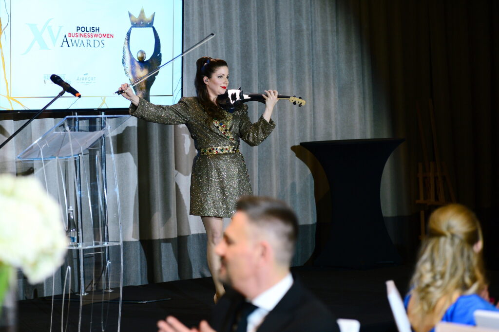 XV Gala Polish Businesswomen Awards w Hotelu Airport Okęcie - kobieta na scenie gra na skrzypcach