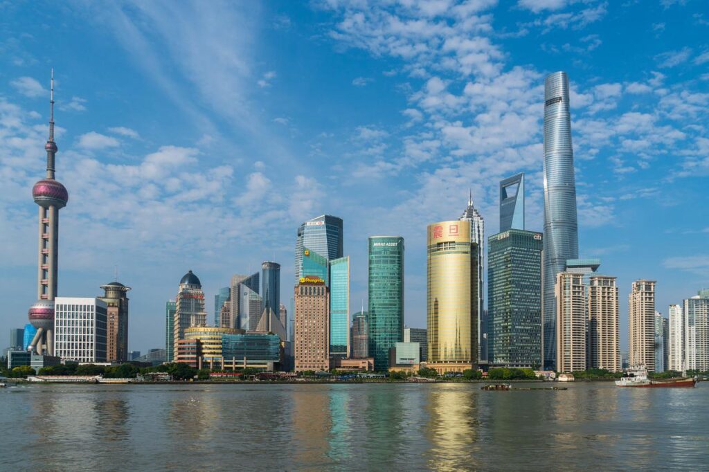 Kolejna fala pandemii spowalnia rozwój gospodarczy Chin - wieżowce z oddali w centrum Szanghaju. 