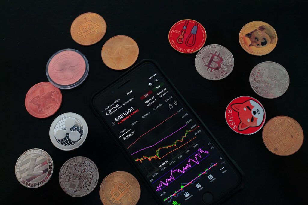 Rynek kryptowalut traci - co powinni zrobić inwestujący? - na stole lężą telefon i monety - kryptowaluty