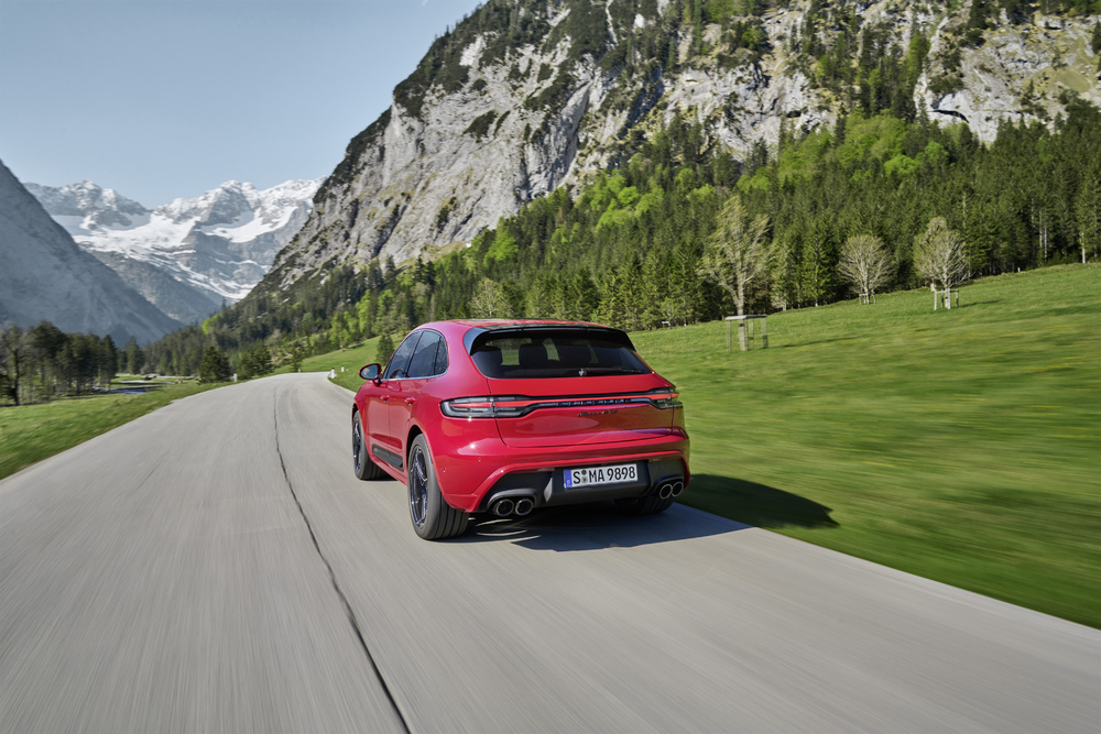 Porsche bije rekordy sprzedaży w Polsce - czerwone auto sportowe jedzie po drodze w otoczeniu krajobrazu gór. 