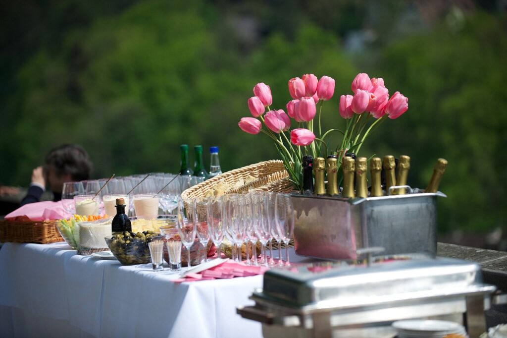 Co czeka rynek eventów w najbliższych miesiącach? - stół z przekąsami, alkoholem i kwiatami. 