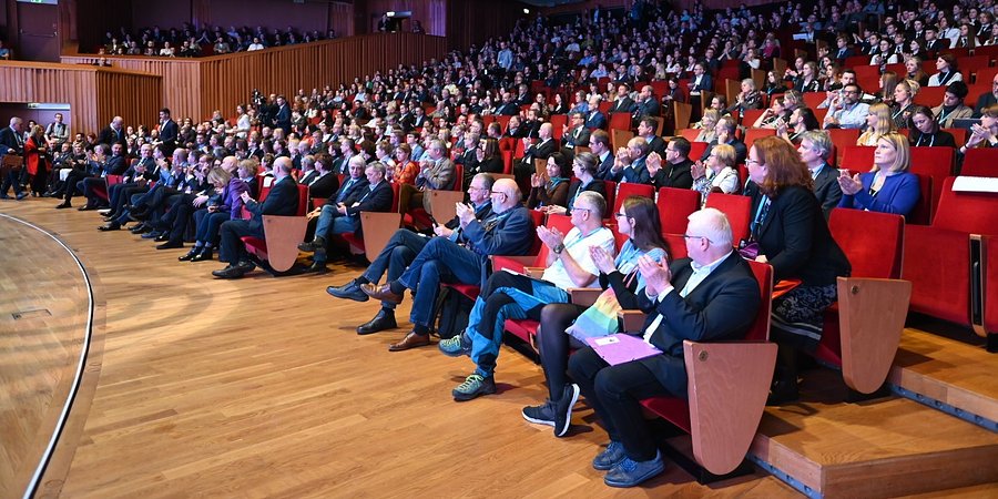 Relacja ze szczytu ekonomicznego Open Eyes Economy Summit 2022 - ludzie siedzą na widowni i klaszczą.