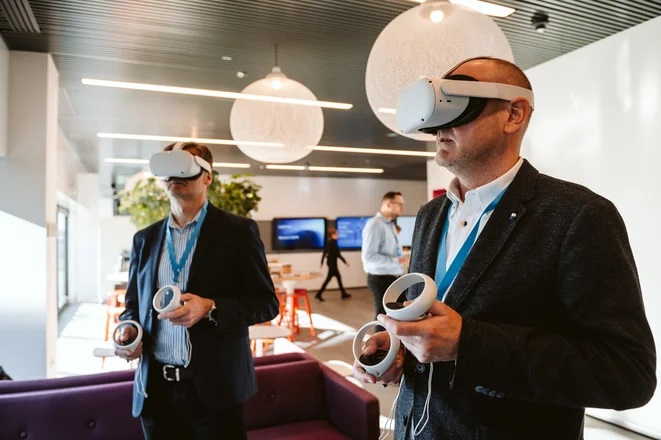 Ericsson uruchamia program szkoleniowy w Metaverse - meżczyzni stoją i graj a w wirtualna grę z okularami na oczach. 