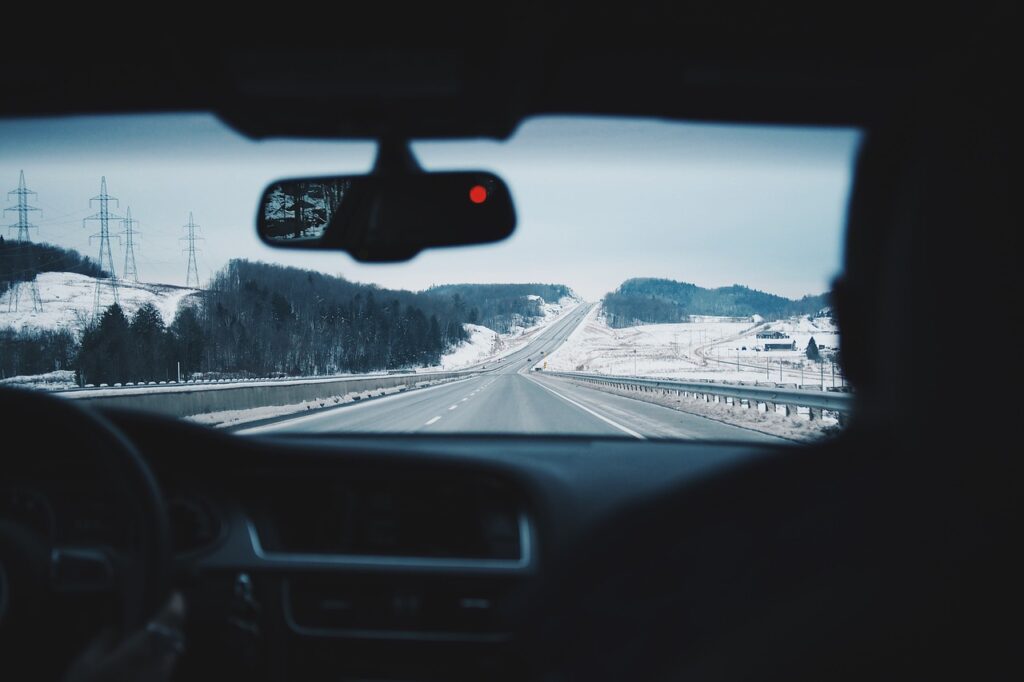 Pierwsza zima z "elektrykiem"? Sprawdź, co musisz wiedzieć - wnętrze auta, za szyby widać krajobraz ze śniegiem.