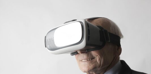 Starszy mężczyzna używający gogli VR w studio